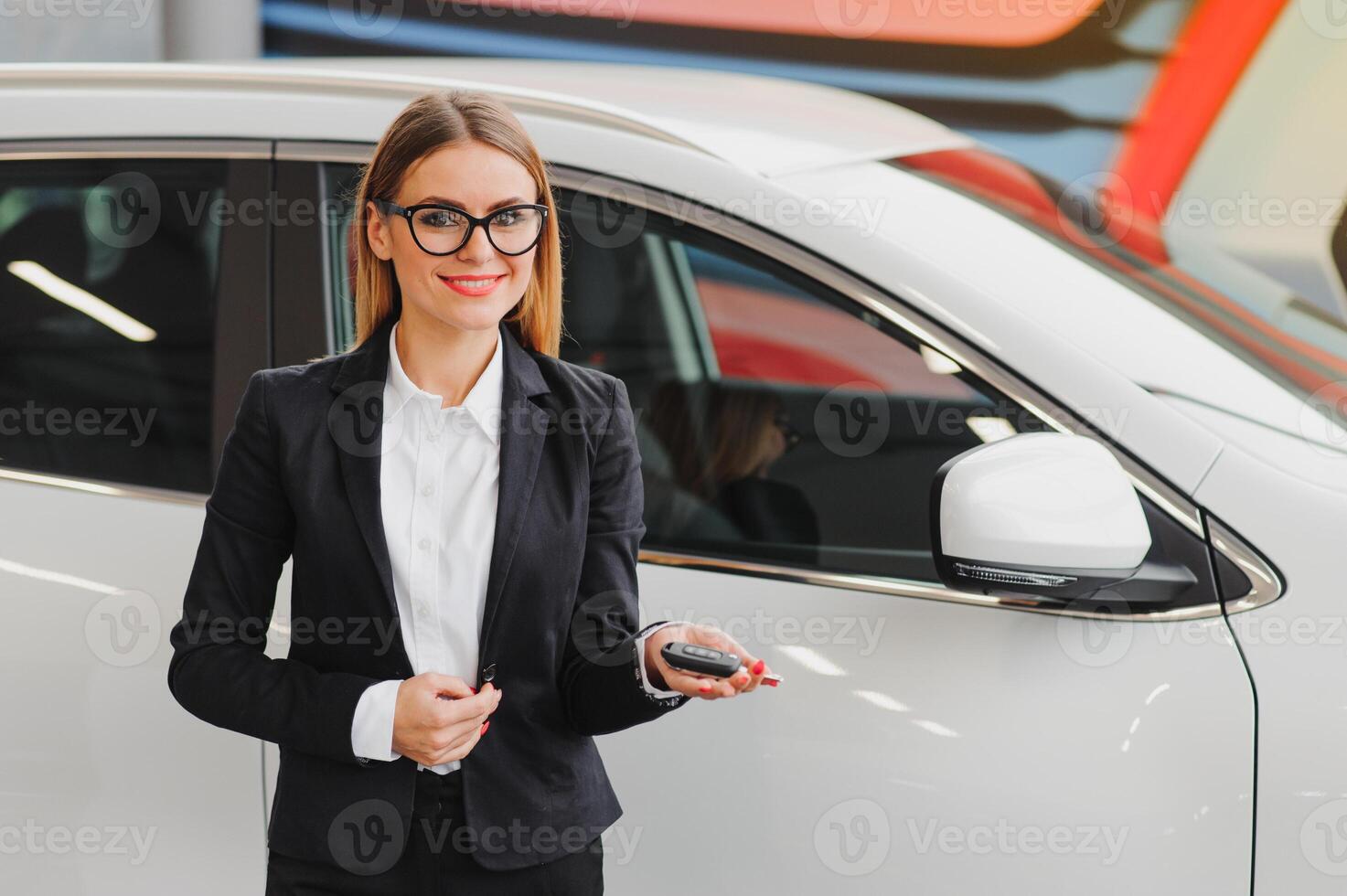 auto negocio, coche venta, consumismo y personas concepto - contento mujer tomando coche llave desde comerciante en auto espectáculo o salón. foto