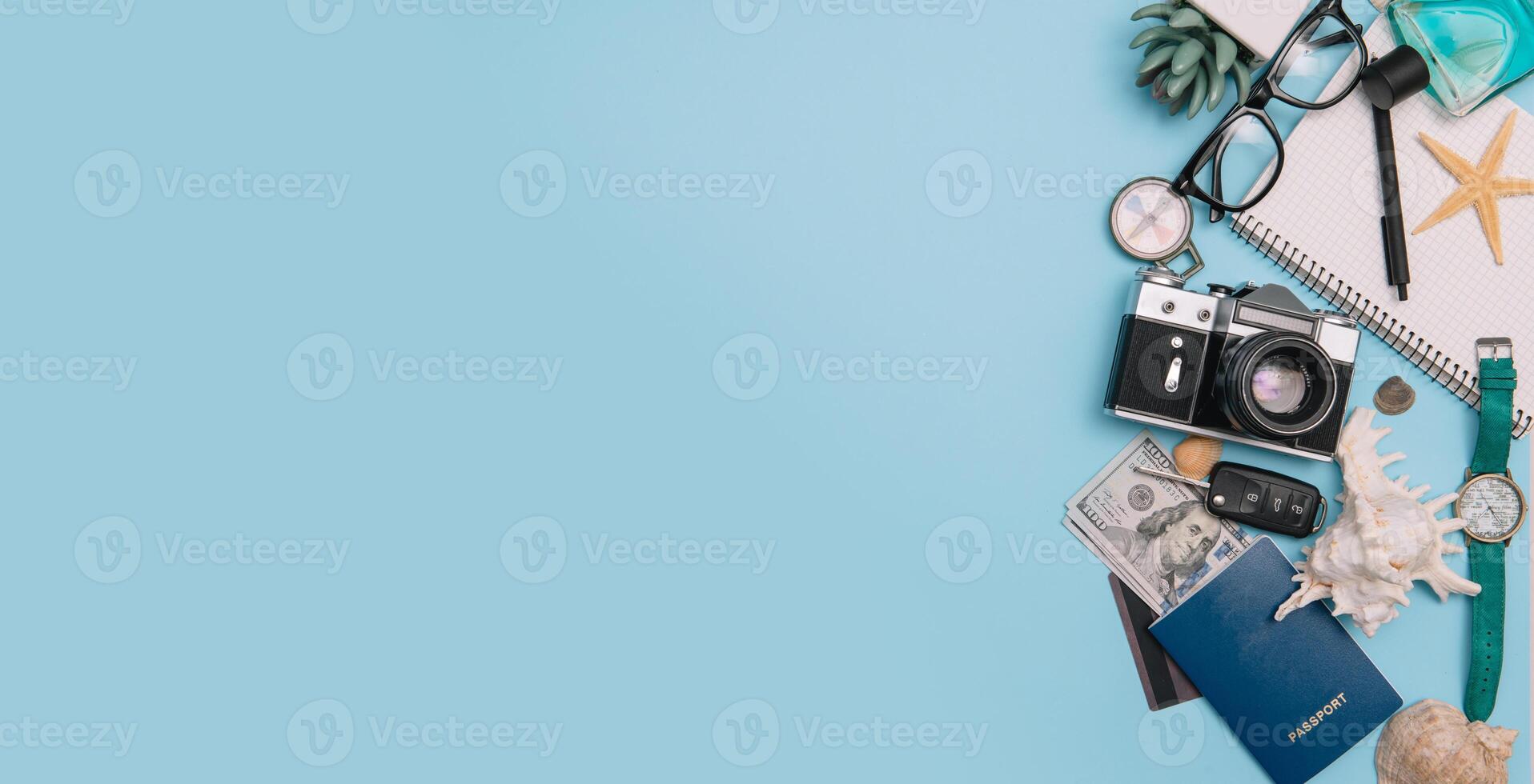 top view travel concept with retro camera films, smartphone, map, passport, compass and Outfit of traveler on blue background with copy space, Tourist essentials, vintage tone effect photo