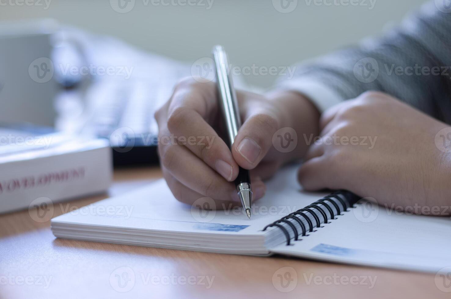hands writing on a blank book in office desk photo