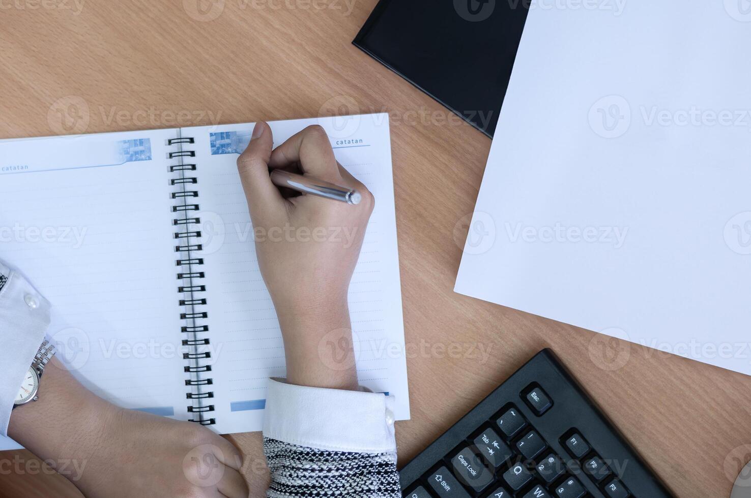 hands writing on a blank book in office desk photo