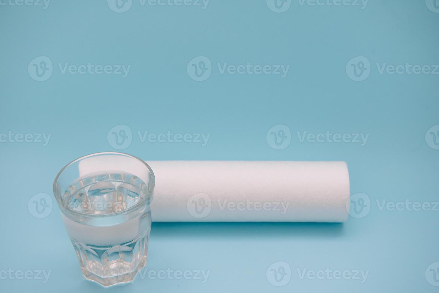 Water filters. Carbon cartridges and a glass on a blue background. Household filtration system. photo