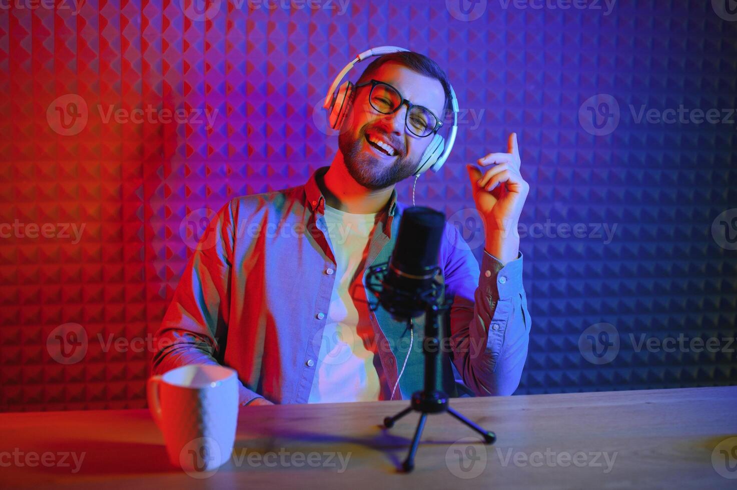 A video blogger records content in his studio. The host of the video blog is a young man who is very enthusiastic about telling his subscribers a story. photo