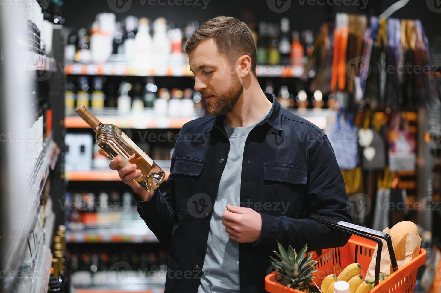 hombre en un supermercado elegir un vino foto