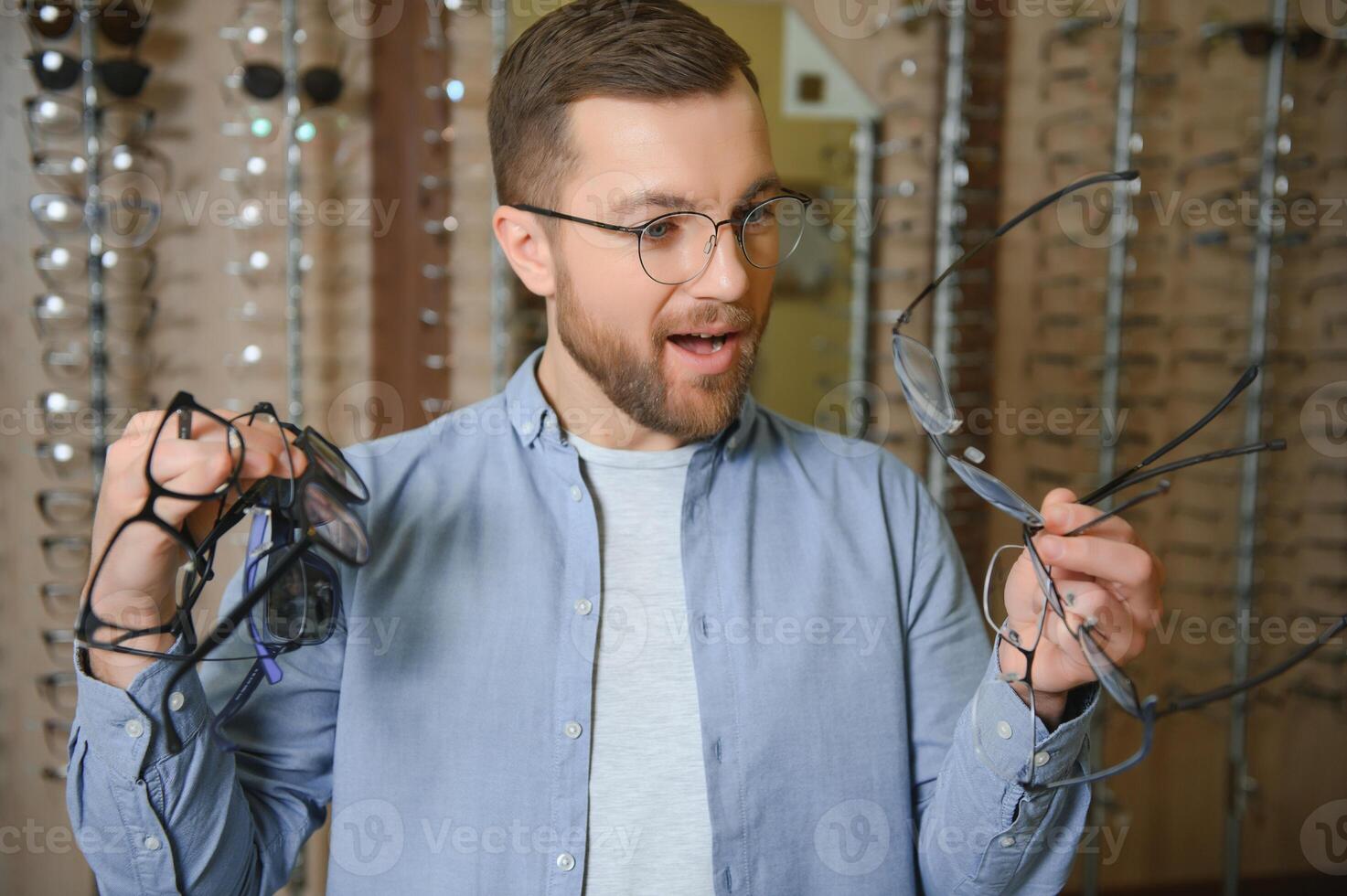 Healthcare, Eyesight And Vision Concept. Happy man choosing glasses at optics store, selective focus photo