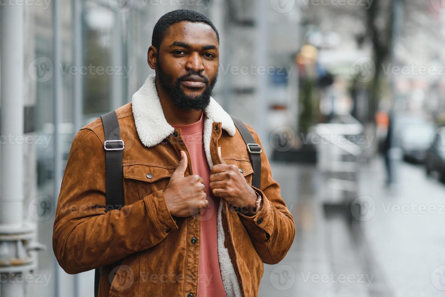 portrait of confident trendy serious african guy in stylish outfit, young afro american male posing at camera, looking away photo