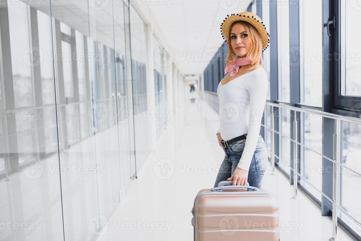 Girl traveler walking with carrying hold suitcase in the airport. Tourist Concept. Woman walks through airport terminal with luggage. travel concept photo