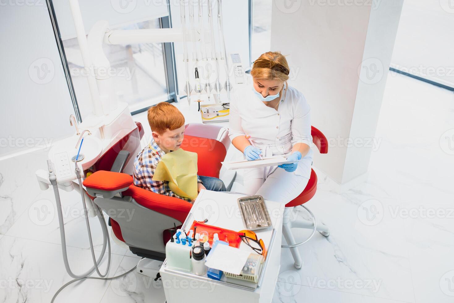 Little boy having his teeth examined by a dentist photo