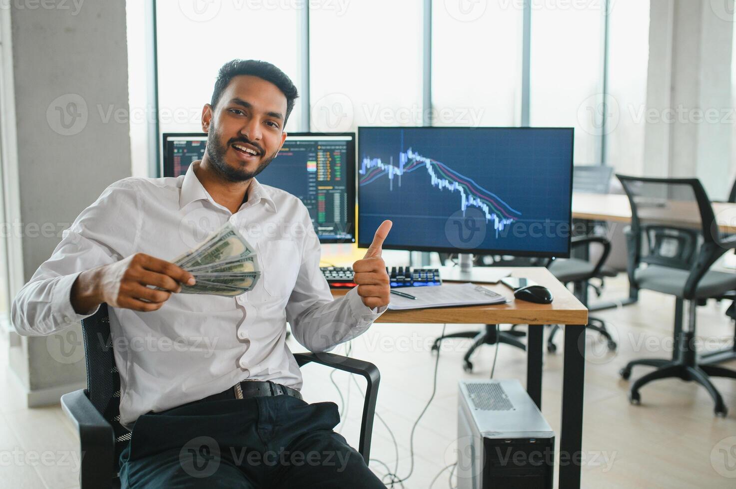 Young indian business man trader looking at computer screen with trading charts reflecting in eyeglasses watching stock trading market financial data growth concept, close up. photo
