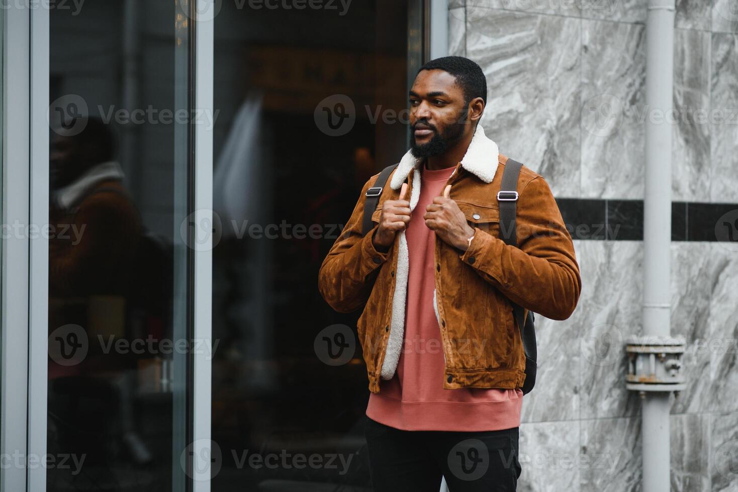 portrait of confident trendy serious african guy in stylish outfit, young afro american male posing at camera, looking away photo