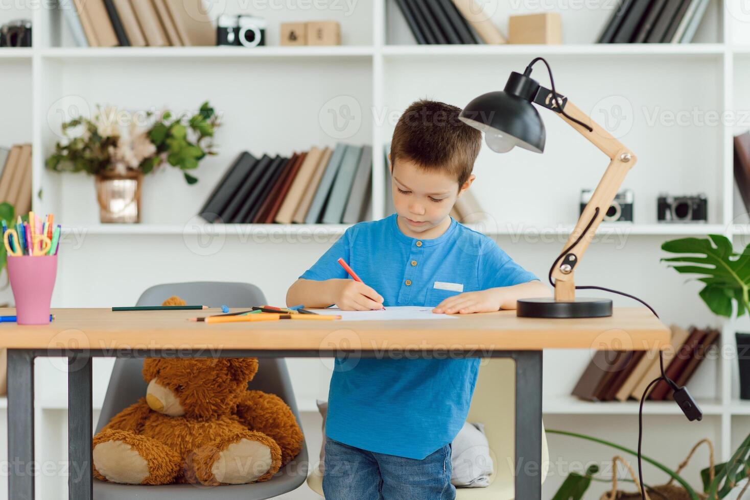 A school-age boy does homework at home. Training at school photo