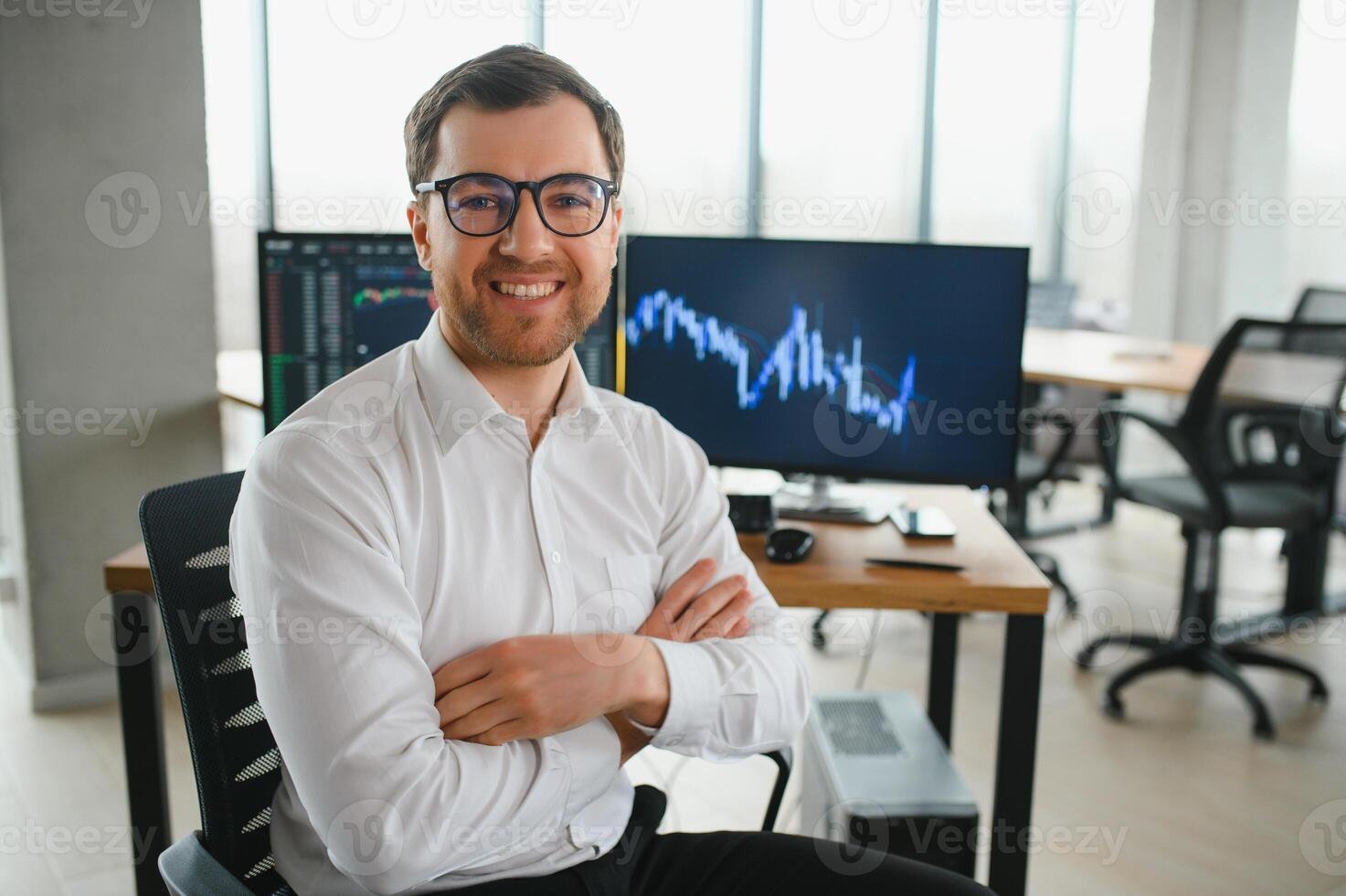 Man trader in formalwear sitting at desk in frot of monitors with charts and data at office browsing laptop checking documents analyzing stocks price changes concentrated. photo