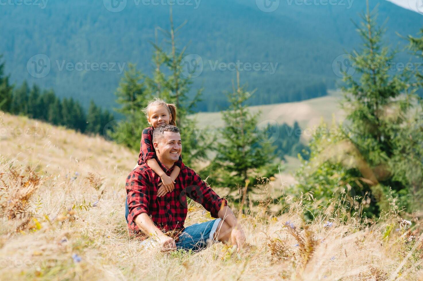 contento padre y pequeño niño son caminando en el montañas. del padre día. vacaciones en el nacional parque foto