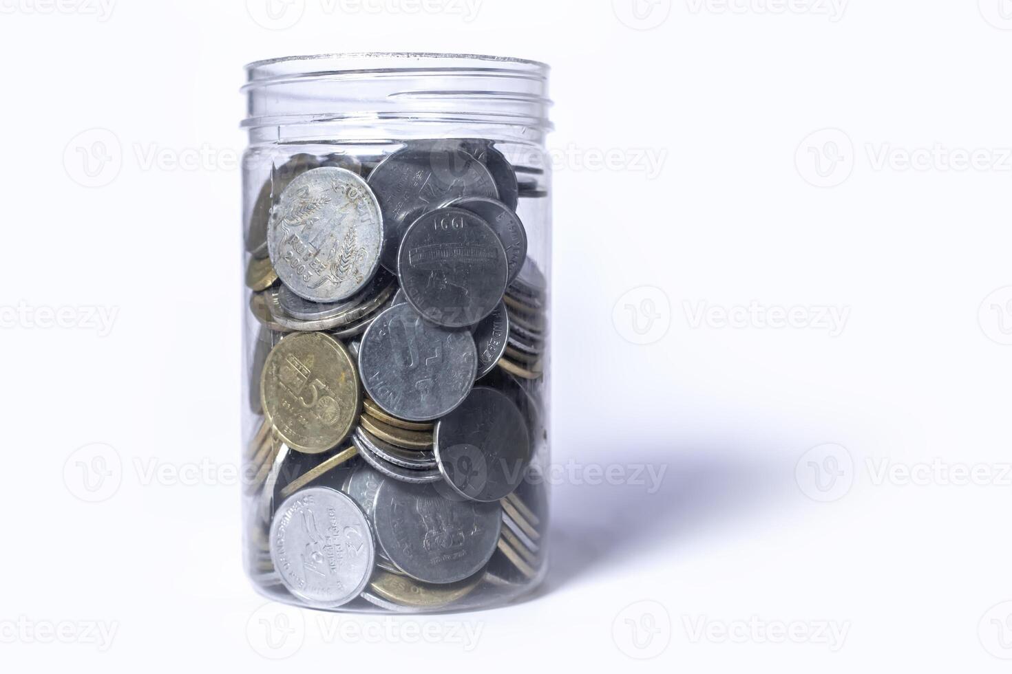 Coins in glass jar isolated on white background with copy space. Saving money concept. photo