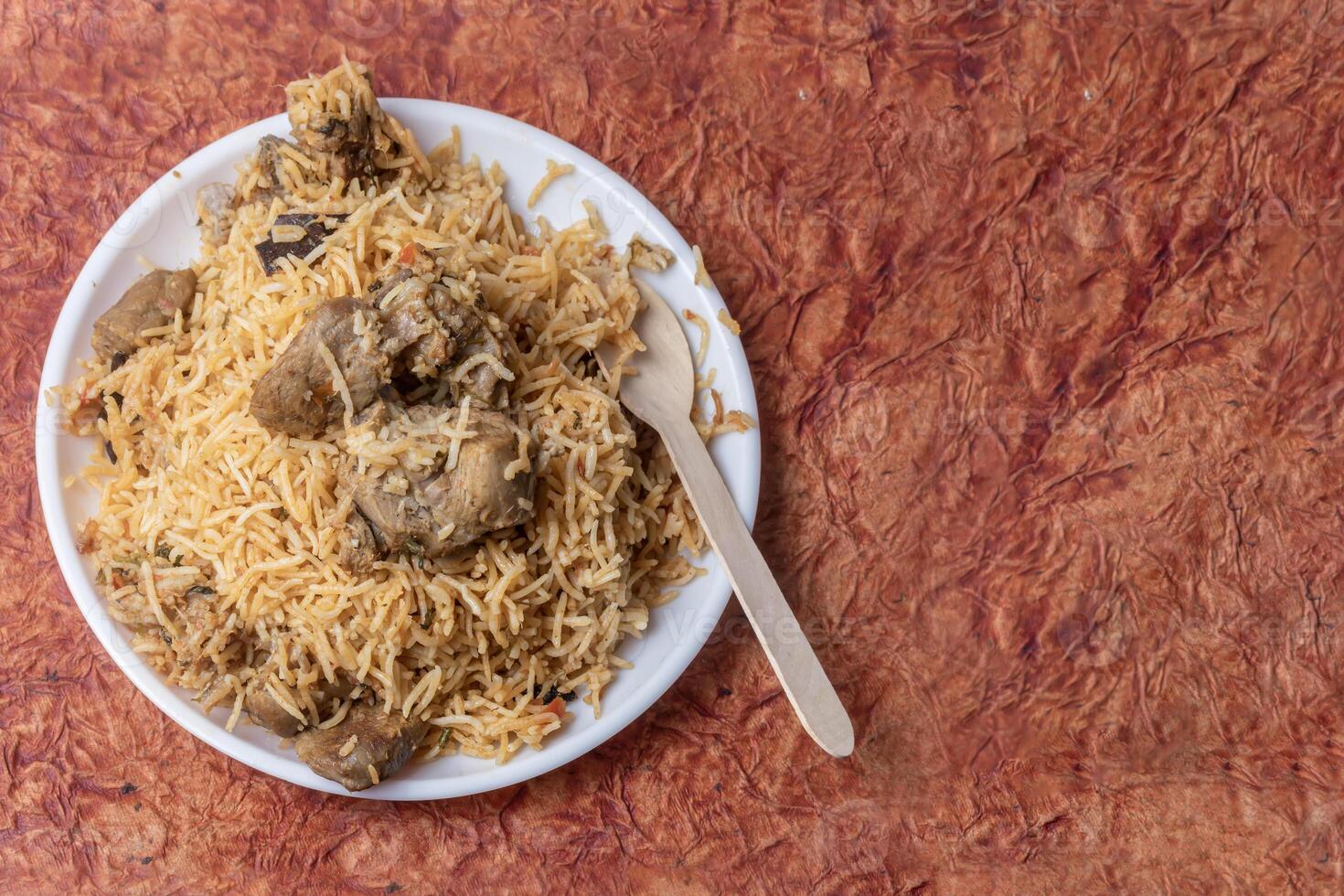 Indian famous mutton biryani dish served on white plate is delicious and fragrant. photo