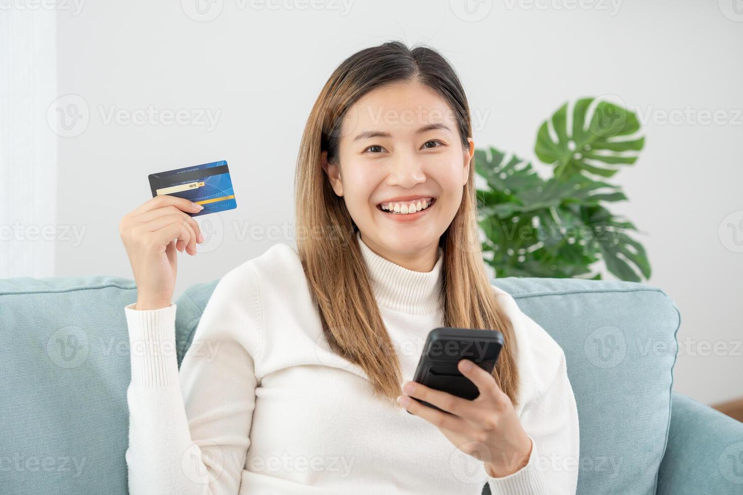 woman using smartphone for online shopping at home. Hand holding mobile phone with payment detail page display and credit card, stay home, technology, electronic commerce, internet, market place photo