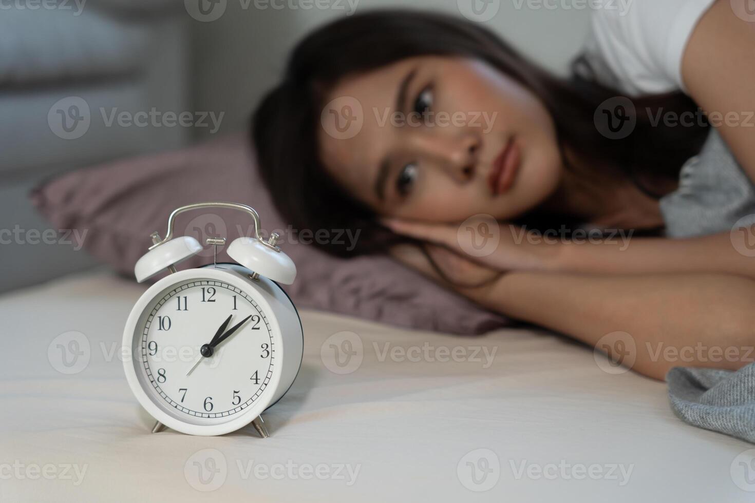 asiático mujer en cama tarde molesto a dormir sufrimiento insomnio, insomne o asustado en un pesadilla, mirando triste preocupado y estresado. cansado y dolor de cabeza o migraña despertar arriba en el medio de el noche. foto