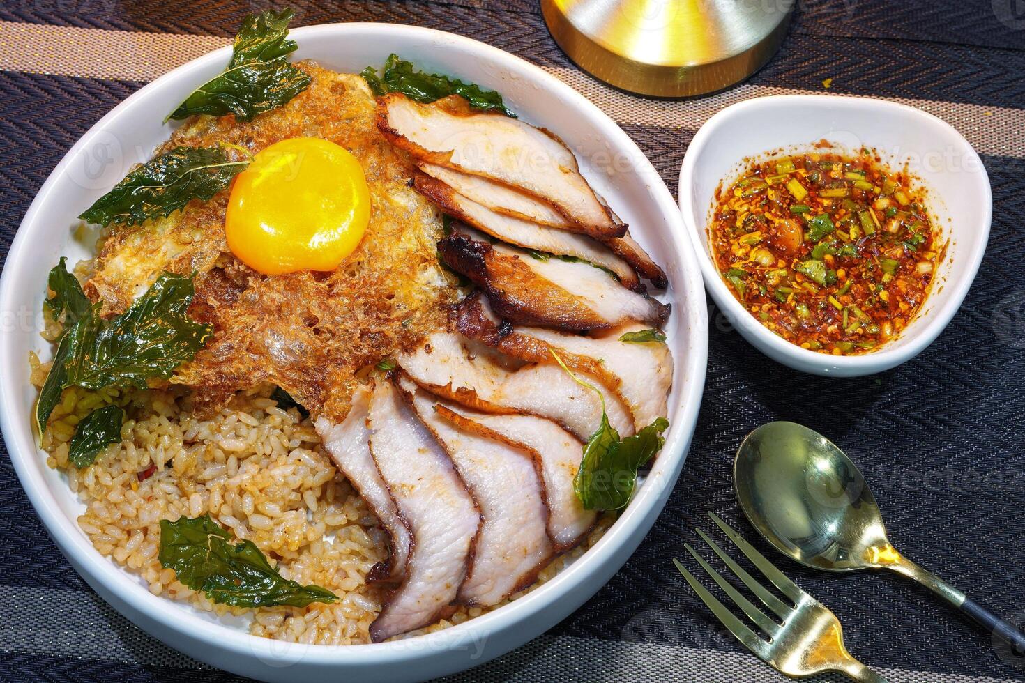 fried rice with Thai basil and grilled belly pork on top with fried egg - Thai food photo