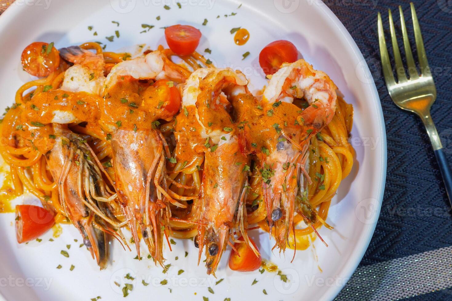 Spicy spaghetti with shrimps in tomato sauce close-up on a plate. top view from above photo