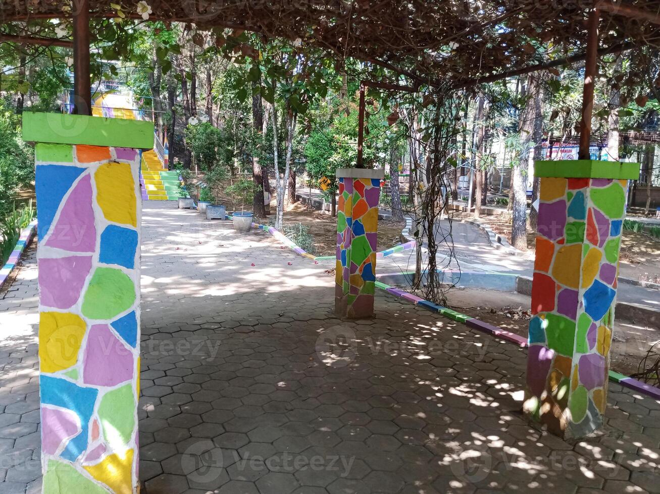 colorful geometric pattern mural pillars in floral garden photo