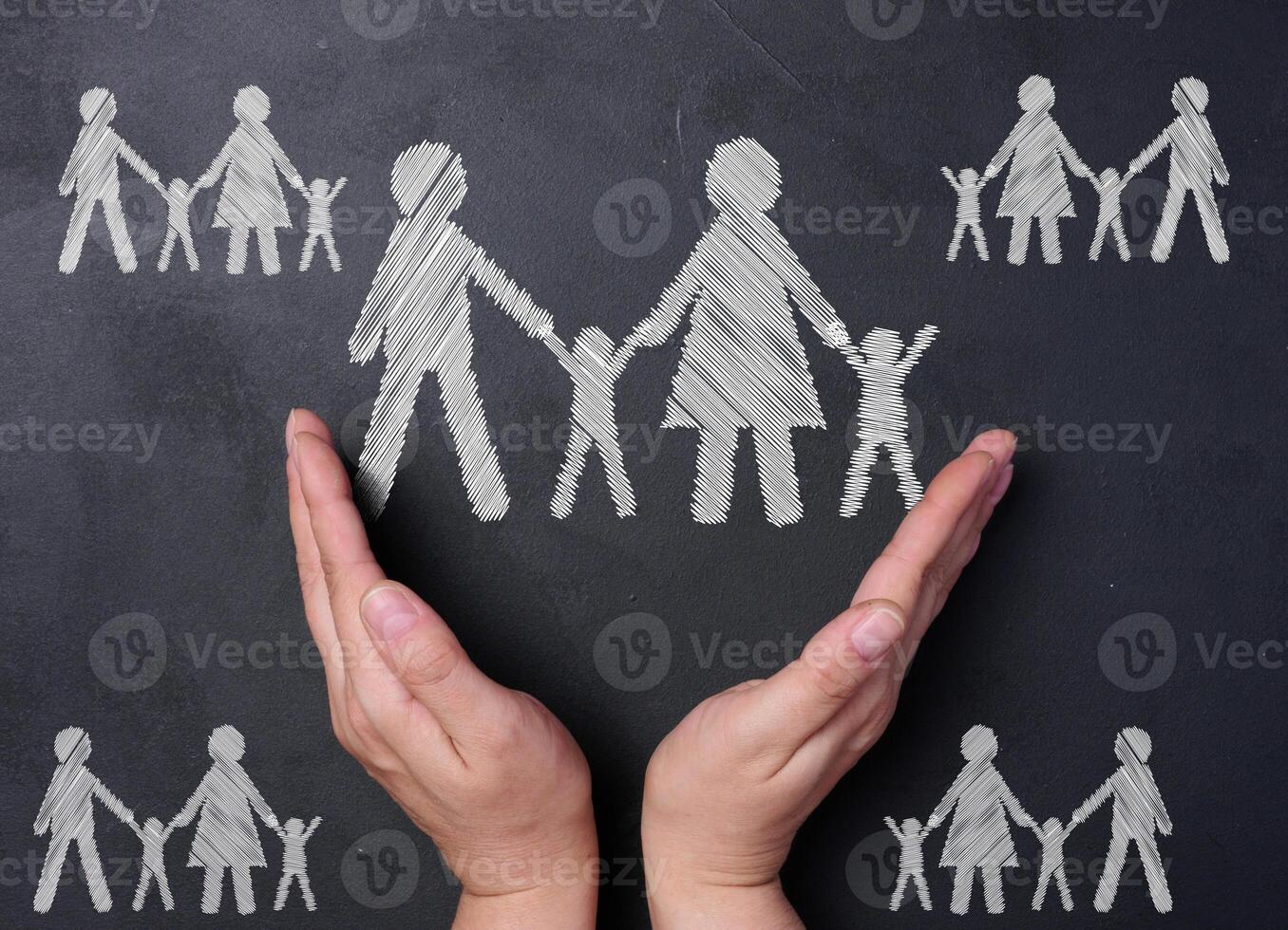 Chalk drawn family on a black board and two female hands, concept of love and support photo