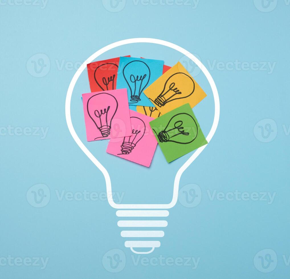 Drawn electric lamps on pieces of paper, the concept of searching for new solutions photo