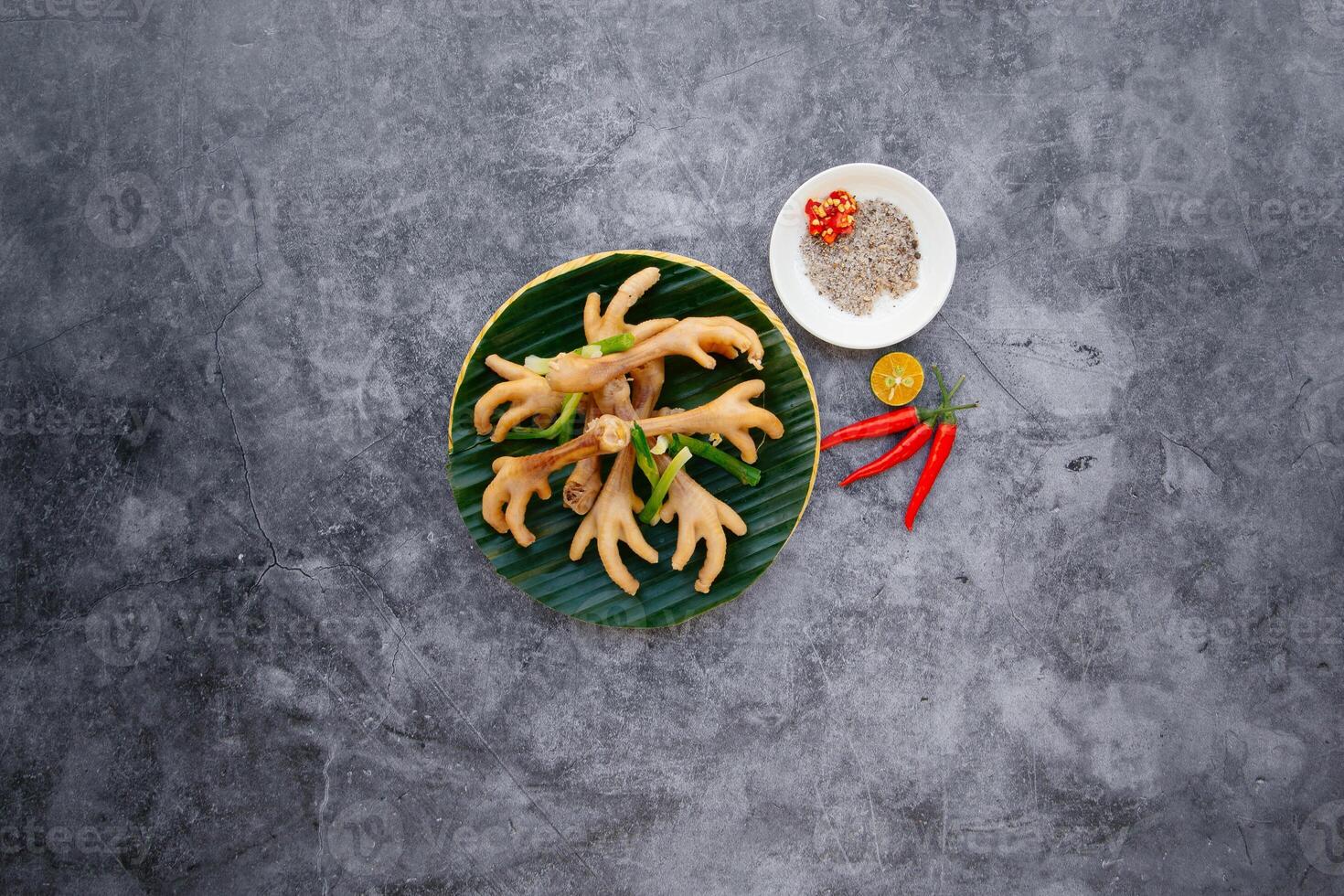 Steamed Chicken Feet with spring onion, garlic and fish sauce served in bowl isolated on dark grey background top view of japanese food photo