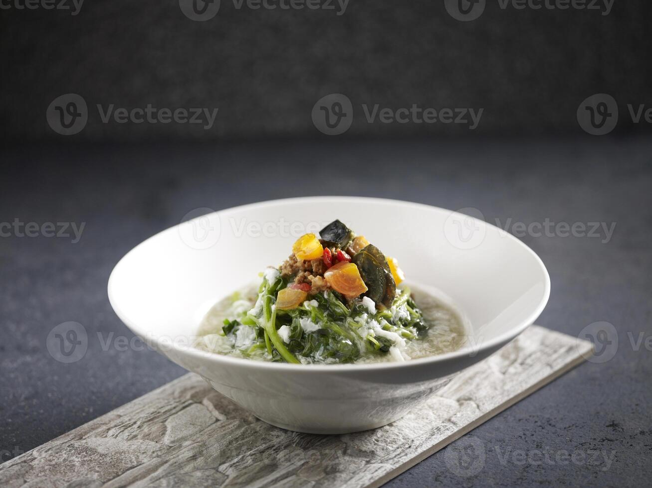 Poached Baby Spinach with Eggs Trio in Superior Broth served in a dish isolated on mat side view on dark background photo
