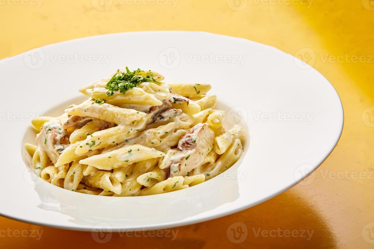 Chicken Alfredo pasta with white sauce served in dish isolated on table top view of arabic tasty fasfood photo