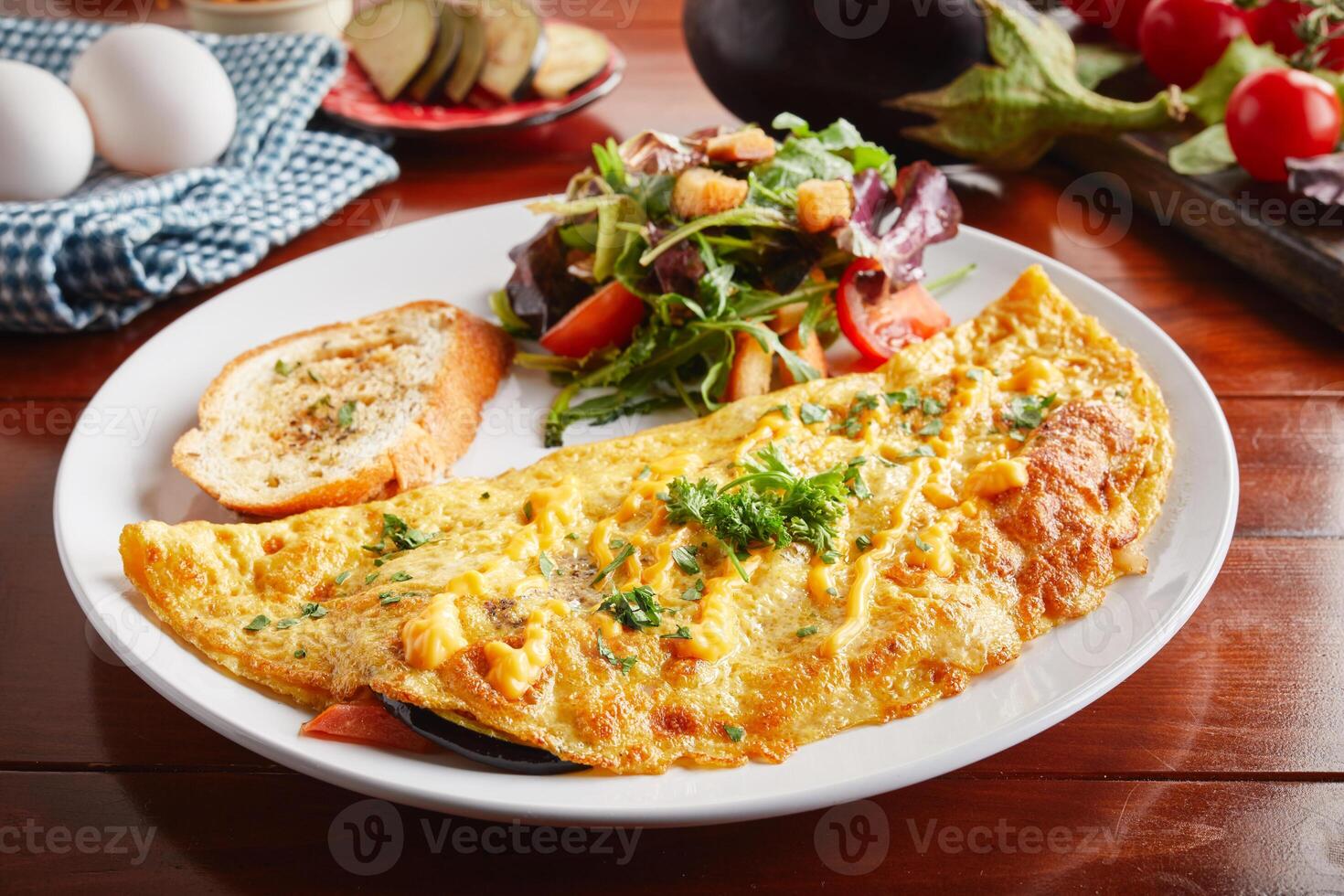 Egg plant cream sauce omelette roll with salad served in a dish isolated on wooden background side view photo