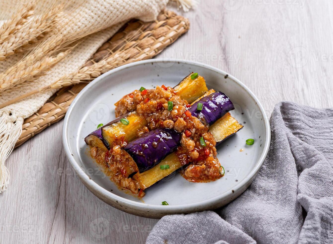 Fried eggplant signature brinjal curry gravy ina dish side view on table photo