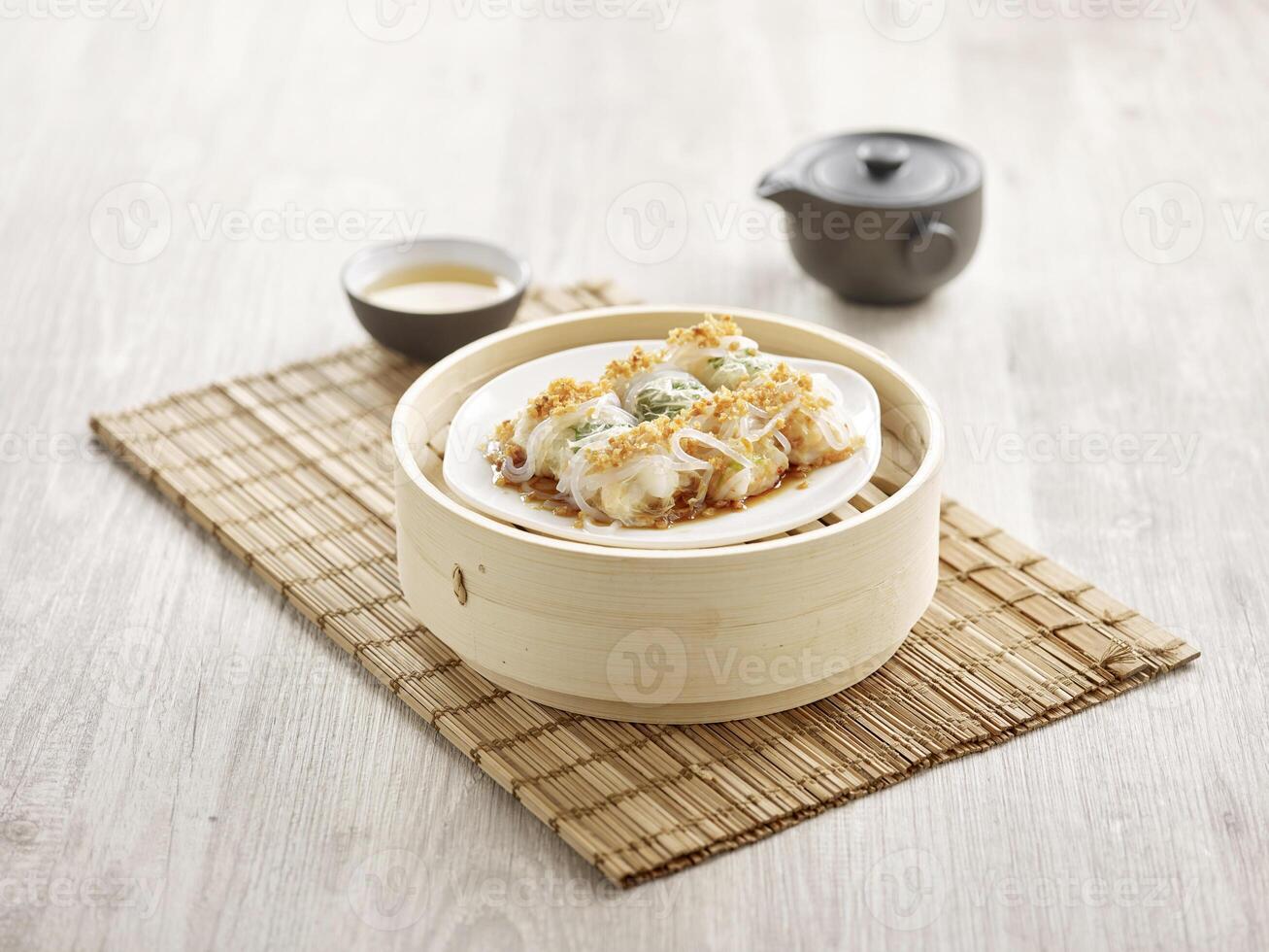 Scallops in Vermicelli Roll with Fried Garlic served in a wooden bowl side view on grey marble background photo