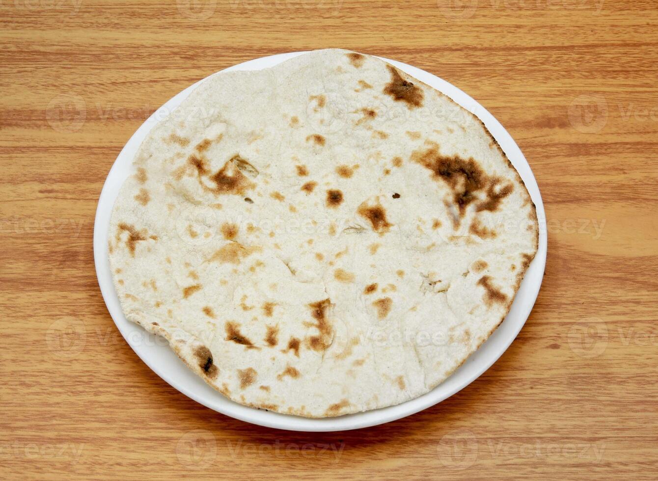 plain tandoori roti or sada roti, nun, tandoori, chapati, pita, bread served in a dish isolated on wooden table side view of indian, pakistani food photo