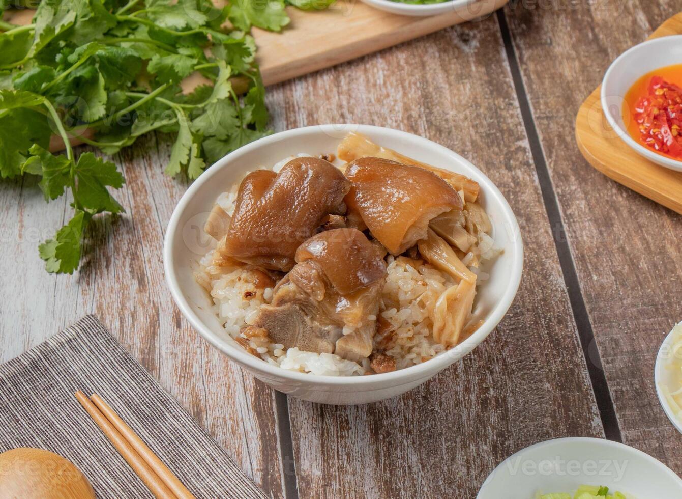 Pig feet rice pork meat with chilli sauce, noodles, spoon and chopsticks served in dish isolated on napkin top view of hong kong food photo
