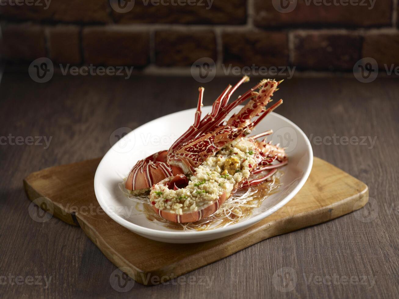 Steamed with Minced Garlic Bamboo Lobster served in a dish side view on wooden background photo