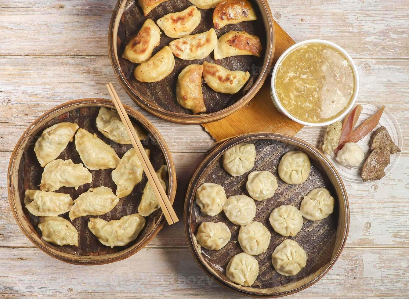 Handmade fried dumplings with steamed dumpling or momo served in wooden dish with Mixed soup chopsticks isolated on table top view Japanese food photo