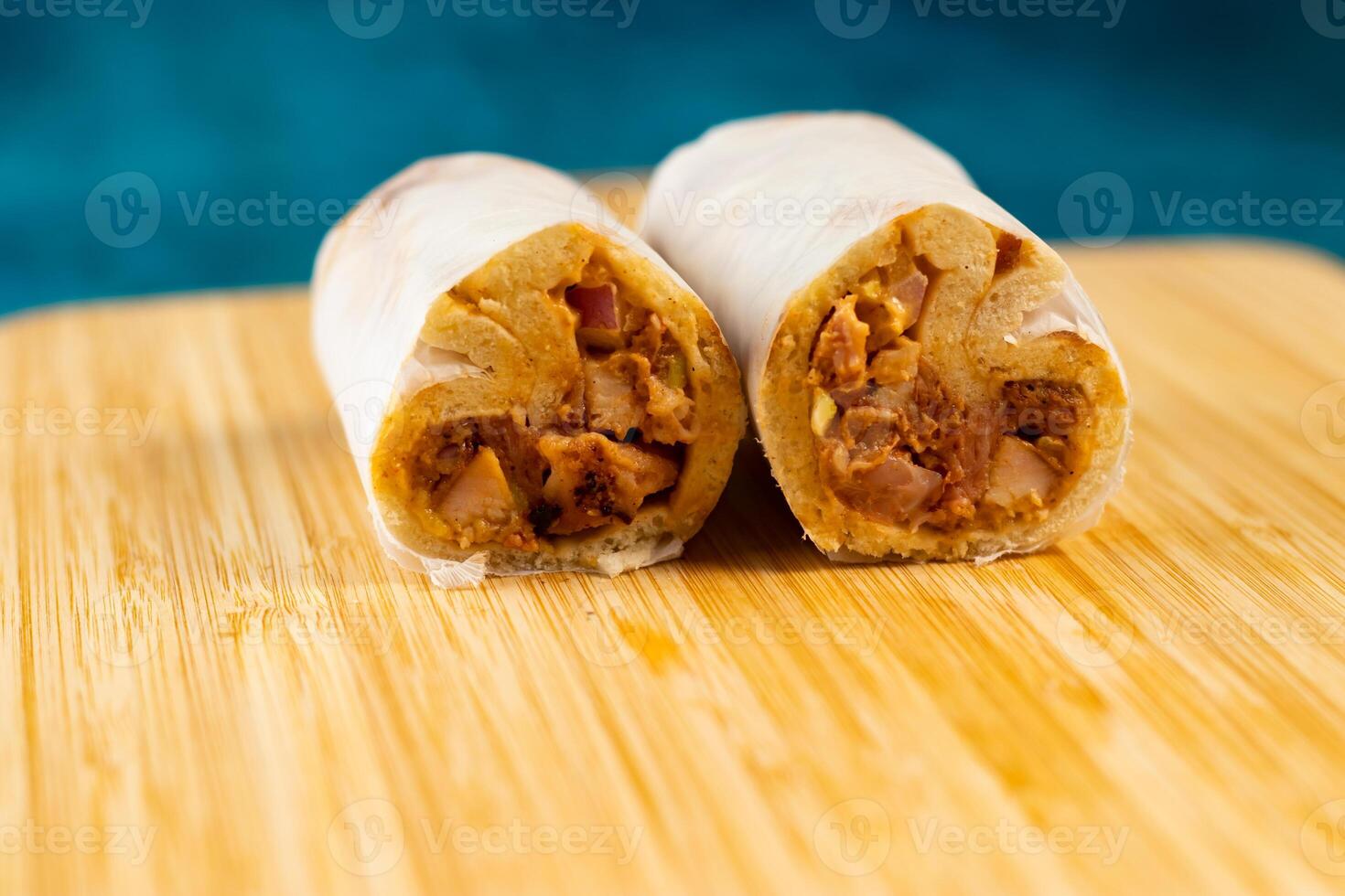 Chicken shawarma roll wrap isolated on wooden board side view of fastfood photo