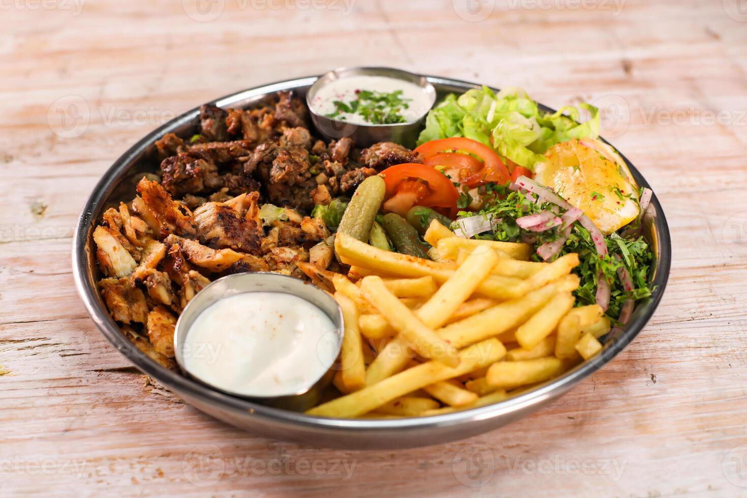 Mix Laham, beef, chicken, dajaj shawarma platter with fries and salad served in dish isolated on table top view fastfood photo