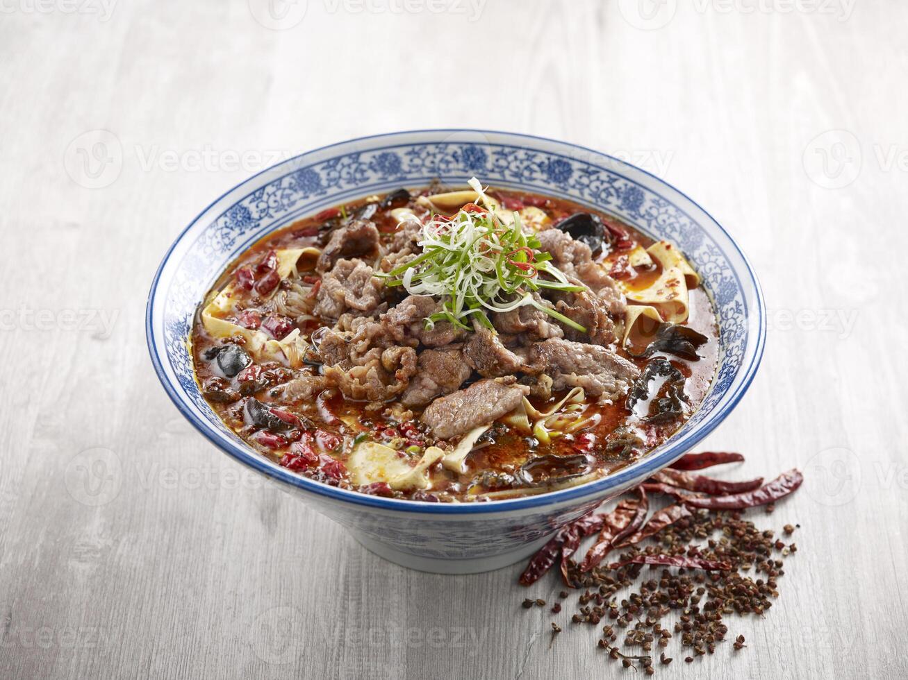 Poached Marbled Beef in Szechuan Style with chopsticks served in a dish isolated on mat side view on grey background photo