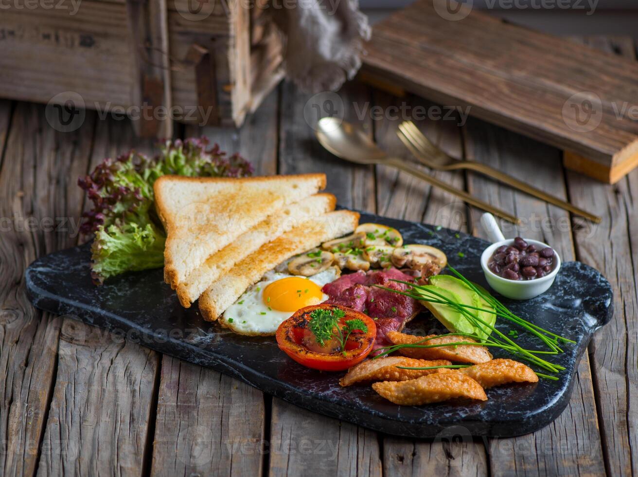 english breakfast with bread, beans, toast, egg, tomato served in a dish isolated on cutting board side view of breakfast on wooden background photo