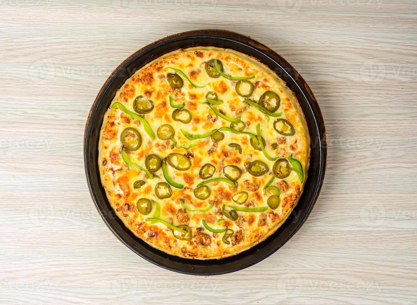Chicken Fajita Pizza isolated on wooden background, spiced chicken cubes and cheese combination on bread, Italian food top view photo