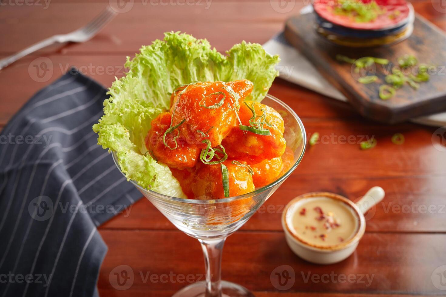 Dynamite egg with dip served in a goblet isolated on wooden background side view photo
