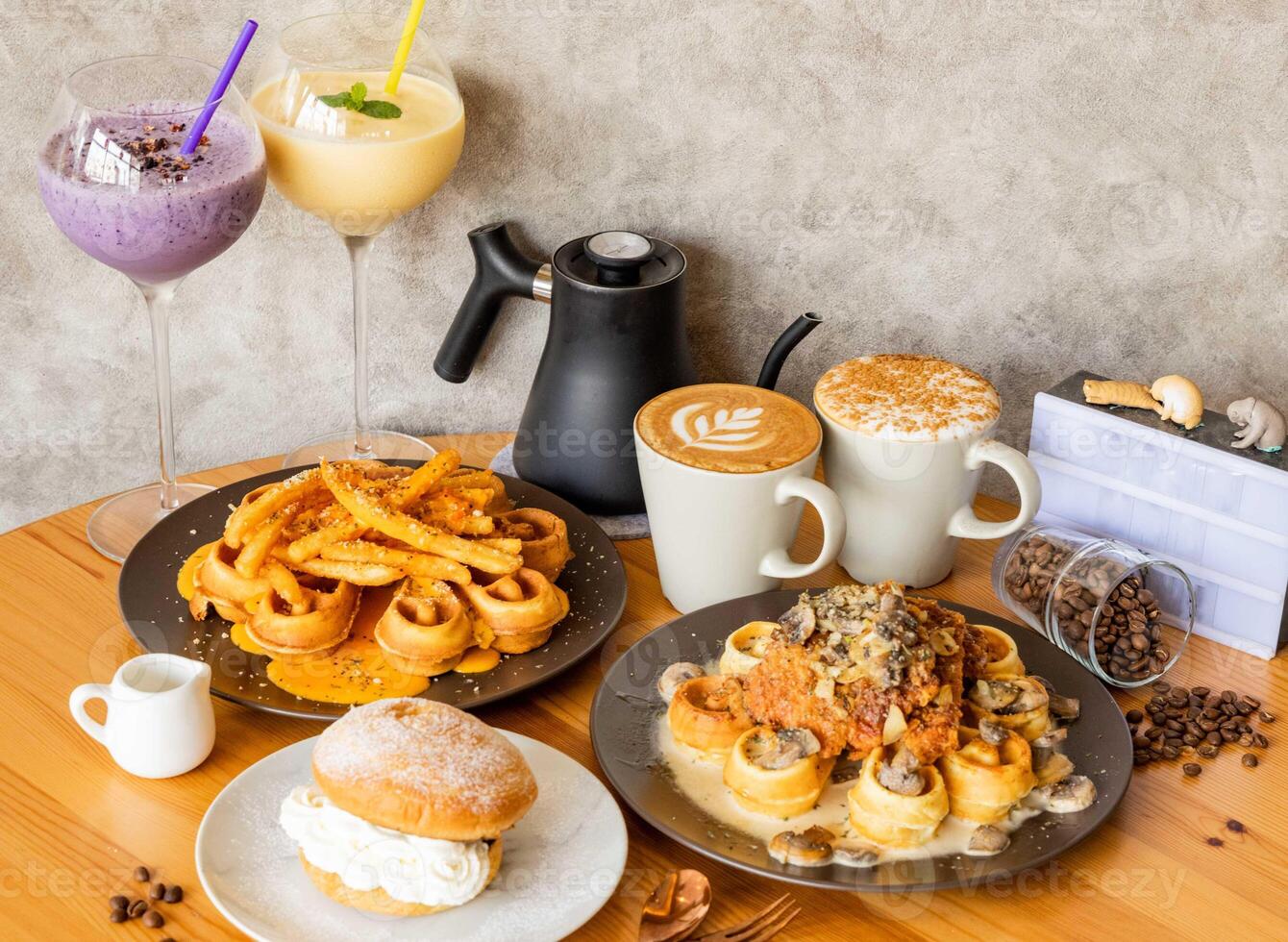 Chicken Waffle with Mushroom Milk, Cheese Potato fries, Cappuccino, mocha latte art, mixed berries and mango milkshake with coffee beans, fork, spoon isolated on wooden table top view of taiwan food photo