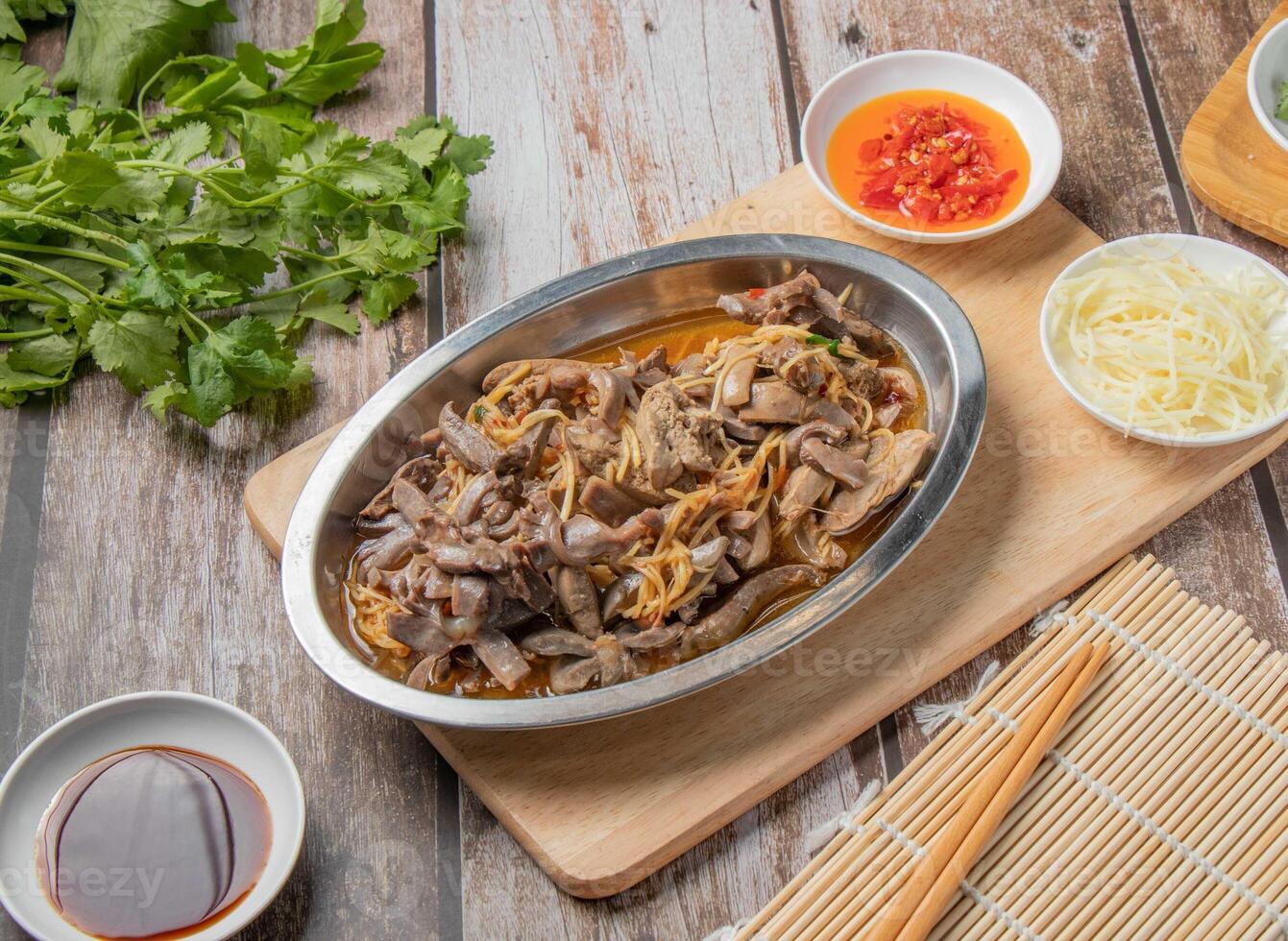 Pork and squid noodles water with chilli sauce, noodles, spoon and chopsticks served in dish isolated on napkin top view of hong kong food photo
