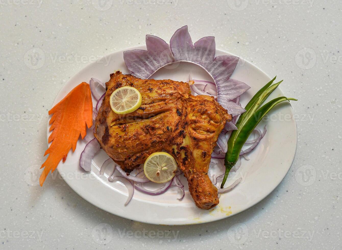 bbq spicy chicken breast piece with lemon slice served in a dish isolated on grey background top view of indian, pakistani food photo