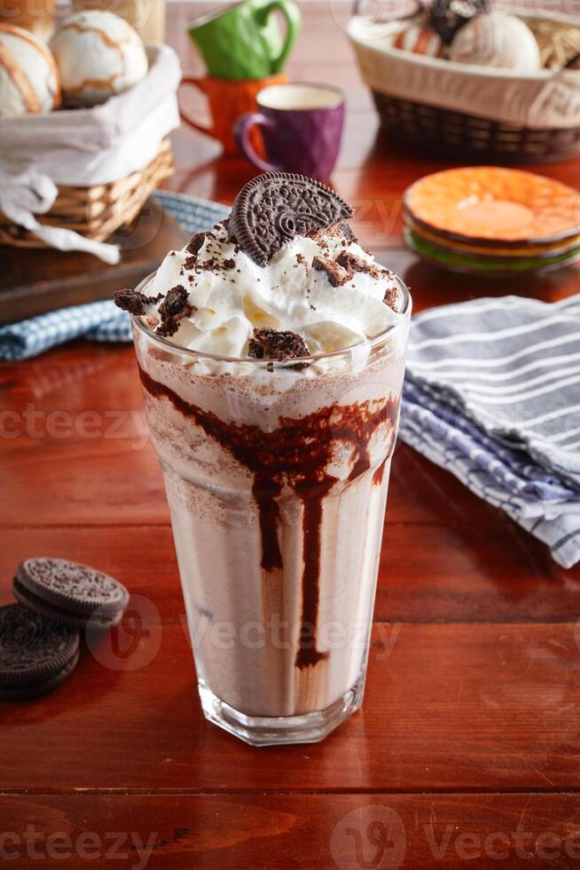 A glass of healthy fresh OREO COOKIES and CREAM FRAPPE isolated on wooden background side view photo