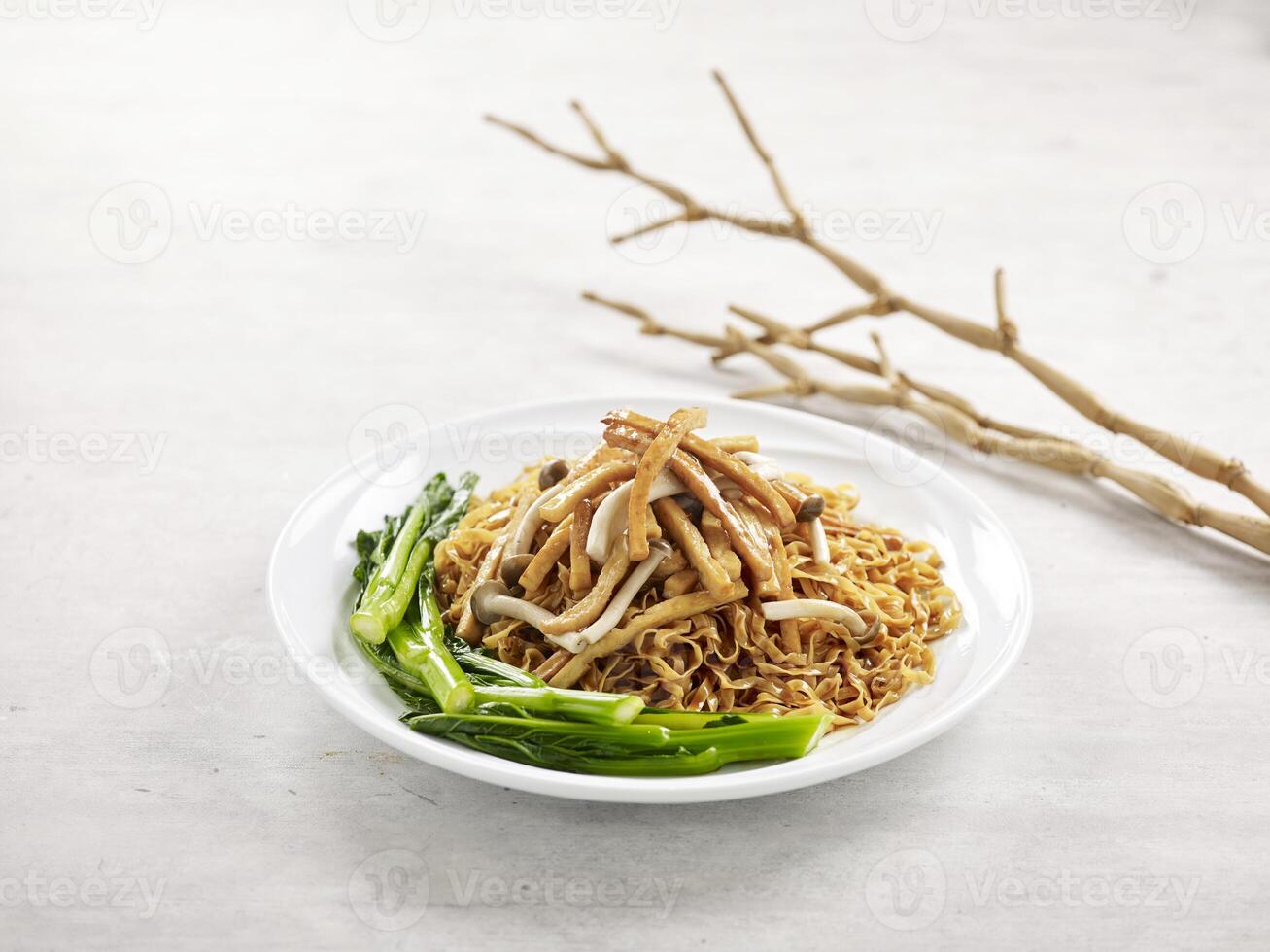 Stewed Mee Pok with Vegetarian Ham served in a dish isolated on wooden board side view on grey background photo