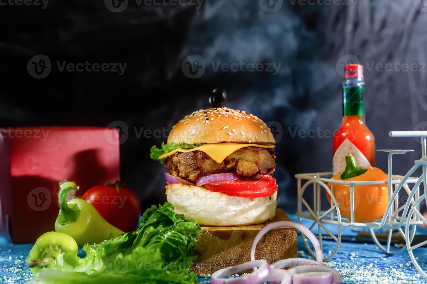 Chicken Cheese Burger with tomato, ketchup and green chilli isolated on wooden board side view of american fast food photo