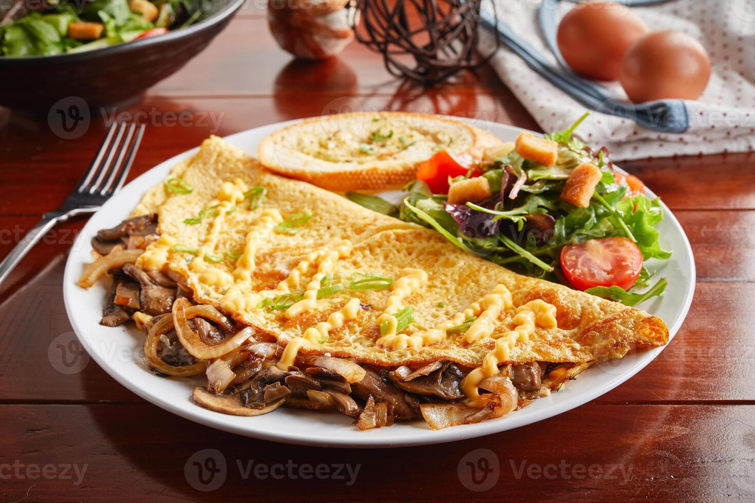 Mushroom Swiss omelette roll with salad served in a dish isolated on wooden background side view photo