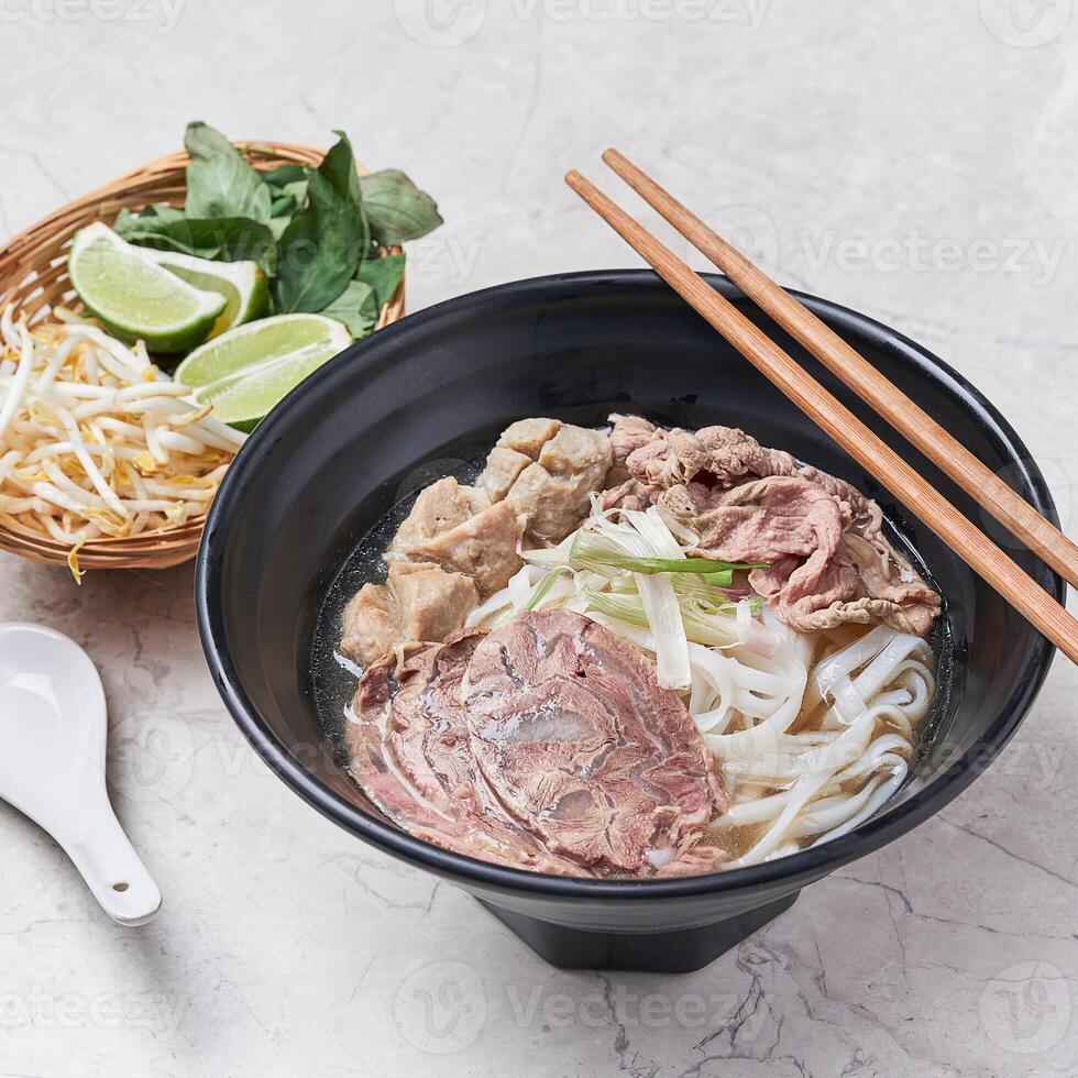 Beef Pho with noodle and lime served in a dish isolated on grey background side view of vietnam food photo