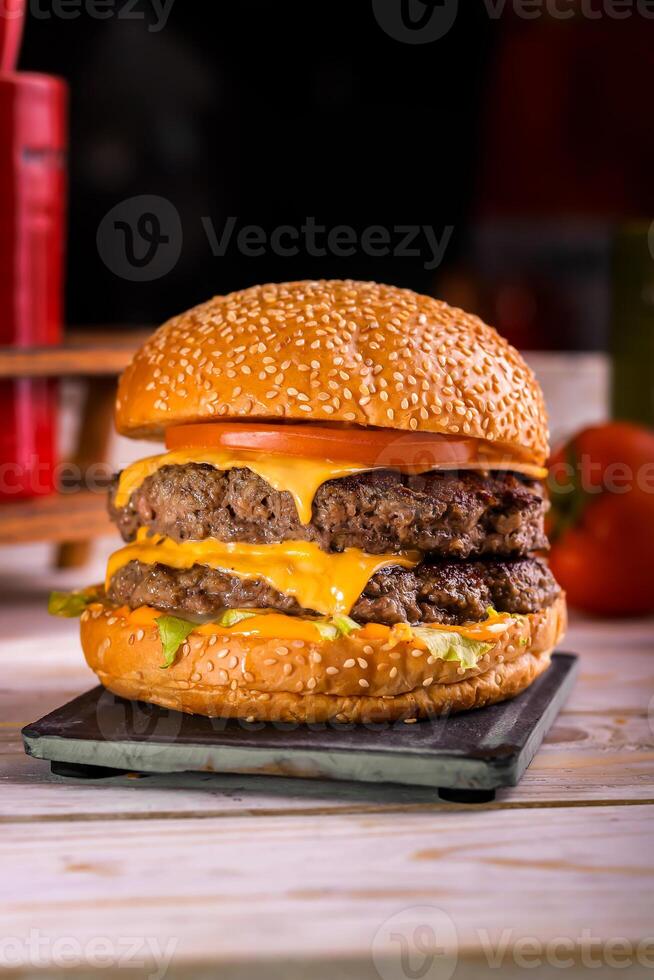 angus carne de vaca doble hamburguesa aislado en corte tablero parte superior ver en oscuro antecedentes americano rápido comida foto